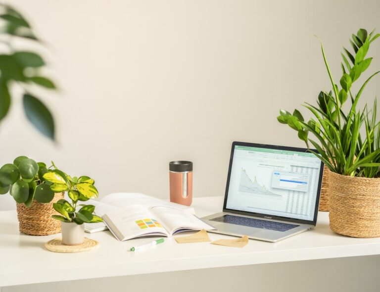 a modern home office setup with laptop, coffee, and plants showing someone working on their online business