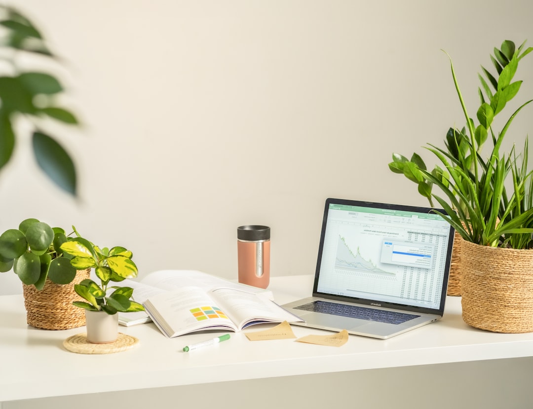 a modern home office setup with laptop, coffee, and plants showing someone working on their online business